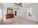 Carpeted main bedroom featuring an ensuite bathroom, large dresser, and ceiling fan at 304 Woods Landing Dr, Lady Lake, FL 32159