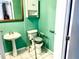 Small bathroom with a pedestal sink and toilet with safety bars at 307 S Hiawassee Rd, Orlando, FL 32835