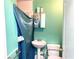 Cozy bathroom featuring a pedestal sink, shower with blue curtain, and toilet with safety bars at 307 S Hiawassee Rd, Orlando, FL 32835