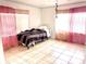 Bright bedroom featuring tile flooring, large windows, and pink curtains at 307 S Hiawassee Rd, Orlando, FL 32835