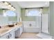 Bright bathroom with double vanities, a soaking tub, and a separate glass-enclosed shower at 3469 Foxton Ct, Oviedo, FL 32765