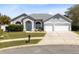 Charming home featuring a well-manicured lawn, symmetrical design, and attached garage at 3469 Foxton Ct, Oviedo, FL 32765