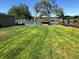 Expansive backyard with lush green grass, wooden fence, and waterfront dock access at 3655 E Osceola Rd, Geneva, FL 32732