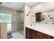 Bathroom with double sink vanity, dark cabinets, and a glass enclosed shower featuring natural light at 3655 E Osceola Rd, Geneva, FL 32732