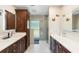 Bathroom with double sink vanity, dark cabinets, and a glass enclosed shower featuring natural light at 3655 E Osceola Rd, Geneva, FL 32732