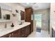 Bathroom with double sink vanity, dark cabinets, and a glass enclosed shower featuring natural light at 3655 E Osceola Rd, Geneva, FL 32732