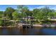 Picturesque view of a waterfront home featuring a private dock, lush greenery, and serene waters at 3655 E Osceola Rd, Geneva, FL 32732