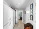 Hallway with ample storage featuring a full wall of white cabinets and a view of the bathroom at 3655 E Osceola Rd, Geneva, FL 32732