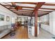Open-concept living room and kitchen with exposed beam ceiling, hardwood floors, and modern stainless steel appliances at 3655 E Osceola Rd, Geneva, FL 32732