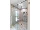 Glass-enclosed shower with gray stone tile, a built-in seat and shelf, and multiple shower heads at 3655 E Osceola Rd, Geneva, FL 32732