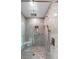Glass-enclosed shower with gray stone tile, a built-in seat and shelf, and multiple shower heads at 3655 E Osceola Rd, Geneva, FL 32732
