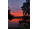 Serene waterfront view featuring a private dock bathed in the vibrant colors of the sunrise at 3655 E Osceola Rd, Geneva, FL 32732