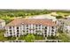 Aerial view of a condo building featuring a red tile roof, surrounded by a lake and lush greenery, offering scenic views at 4114 Breakview Dr # 11002, Orlando, FL 32819