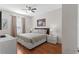 Cozy bedroom with a queen bed, wood floors, and a window with neutral drapes at 4114 Breakview Dr # 11002, Orlando, FL 32819