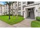 Well-maintained condo building entrance with green grass, manicured bushes, and palm trees, creating a welcoming atmosphere at 4114 Breakview Dr # 11002, Orlando, FL 32819