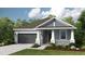 Charming single-Gathering home featuring a two-car garage, manicured lawn, and welcoming front porch at 4147 Coral Harbour Rd, Kissimmee, FL 34758