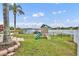 Backyard with a play set and lush green lawn and serene water views beyond a black fence at 417 Barclay Ave, Altamonte Springs, FL 32701
