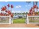 Backyard with lake view, colorful plants, white fence, and a covered boat dock at 417 Barclay Ave, Altamonte Springs, FL 32701