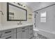 Modern bathroom showcasing a gray vanity, black hardware, and tiled shower with white subway tile at 417 Barclay Ave, Altamonte Springs, FL 32701