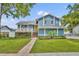 Charming blue two-story home featuring a yellow door, a welcoming front porch, and lush landscaping at 417 Barclay Ave, Altamonte Springs, FL 32701