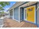 Inviting front porch with charming details, decorative railing, beautiful flowers and a striking yellow door at 417 Barclay Ave, Altamonte Springs, FL 32701