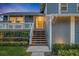 Inviting front porch with charming details, decorative railing, beautiful flowers and a striking yellow door at dusk at 417 Barclay Ave, Altamonte Springs, FL 32701