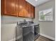 Laundry room featuring wood cabinets, new washer/dryer, and a window for natural light at 417 Barclay Ave, Altamonte Springs, FL 32701