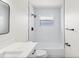 All-white bathroom featuring a shower over tub, subway tile surround, modern fixtures, and a window at 4729 Arrow Rd, Orlando, FL 32812