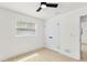 Bright bedroom featuring a ceiling fan, window, neutral walls, and light-colored wood-look flooring at 4729 Arrow Rd, Orlando, FL 32812