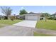 Inviting single-story home with a freshly painted driveway and a neatly maintained front yard, perfect for families at 4729 Arrow Rd, Orlando, FL 32812