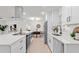 Modern kitchen with stainless appliances, white cabinets, and open concept flow to dining area at 4729 Arrow Rd, Orlando, FL 32812