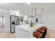Modern kitchen boasts white cabinets, stainless appliances, a large island with seating, and sleek countertops at 4729 Arrow Rd, Orlando, FL 32812