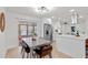 Modern eat-in kitchen features stainless steel appliances, white cabinets, and a dining table with backyard pool view at 4729 Arrow Rd, Orlando, FL 32812