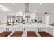 Bright open-concept kitchen featuring a stainless vent hood, white countertops and cabinets, and seating at the island at 4729 Arrow Rd, Orlando, FL 32812