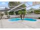 Screened pool area features a uniquely shaped pool, complemented by palm trees and a surrounding patio at 4729 Arrow Rd, Orlando, FL 32812