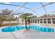 Enclosed pool area with a uniquely shaped pool, palm trees, and the home's exterior, offers a private retreat at 4729 Arrow Rd, Orlando, FL 32812