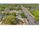 An aerial view of a house with a long street and pond nearby, showing the roof and surrounding trees at 5201 Van Aken Dr, Orlando, FL 32808