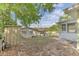 View of backyard with shed and adjacent building, partially fenced and leaves scattered on the sand at 5201 Van Aken Dr, Orlando, FL 32808
