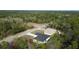 An aerial view of a newly built home surrounded by lush green trees and a road nearby at 54 Malauka Trak, Ocklawaha, FL 32179