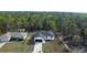 Aerial view of a house with black roof on a spacious lot surrounded by lush trees at 54 Malauka Trak, Ocklawaha, FL 32179