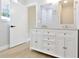 Bathroom with a modern vanity, double sinks, wood-look flooring, and a walk-in shower at 54 Malauka Trak, Ocklawaha, FL 32179