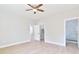 Bright bedroom with wood-look flooring and neutral walls, offering access to closet and bathroom at 54 Malauka Trak, Ocklawaha, FL 32179