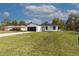 Charming one story home has black trim and roof, a 1-car garage, and a well-maintained lawn at 54 Malauka Trak, Ocklawaha, FL 32179