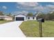 Inviting single-story home with manicured lawn, black mailbox, and a modern black-and-white color scheme at 54 Malauka Trak, Ocklawaha, FL 32179