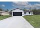 Charming single-story home with a modern black-and-white color scheme and a spacious driveway at 54 Malauka Trak, Ocklawaha, FL 32179