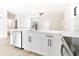 Bright kitchen with a stainless steel dishwasher, a modern faucet, and elegant white cabinetry at 54 Malauka Trak, Ocklawaha, FL 32179