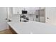 Modern kitchen featuring white cabinets, quartz countertops, stainless steel appliances and black hardware at 54 Malauka Trak, Ocklawaha, FL 32179