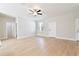 Spacious living room with wood-look floors, ceiling fan, and views into other parts of the home at 54 Malauka Trak, Ocklawaha, FL 32179