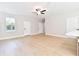 Bright living room featuring wood-look floors, a ceiling fan, and large windows for natural light at 54 Malauka Trak, Ocklawaha, FL 32179