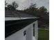 Close-up of the dark roof of this home, white trim, and black rain gutters at 54 Malauka Trak, Ocklawaha, FL 32179